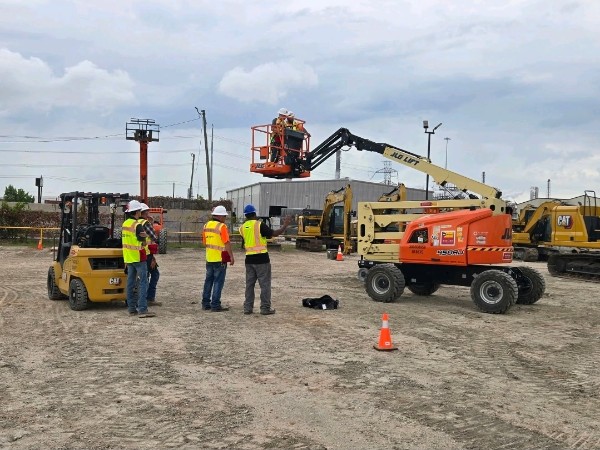Operators training on a JLG boom lift at a Texas construction jobsite