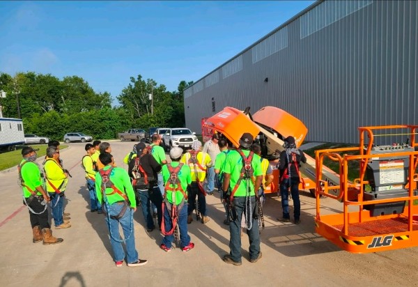 Crew wearing personal fall arrest harnesses during on-site fall protection training