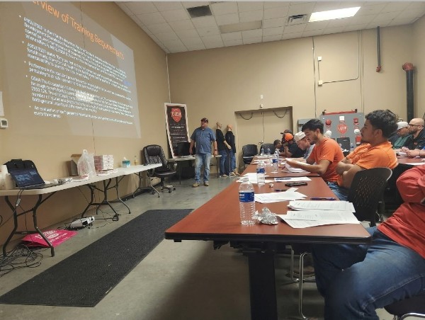 Instructor reviewing OSHA training requirements with a warehouse crew